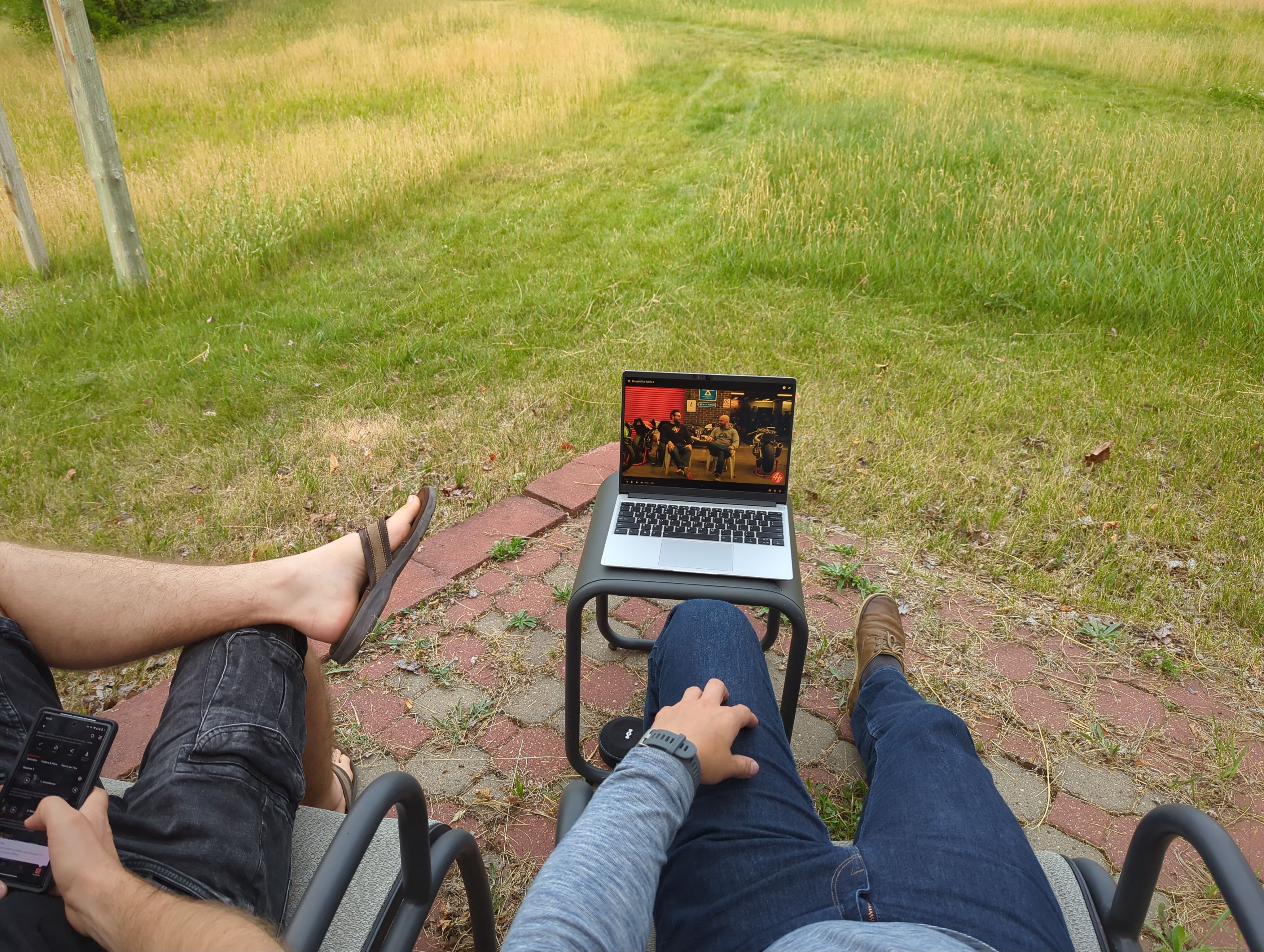 Brent and I watching the Budget Bike Battle Youtube show outdoors on a laptop.