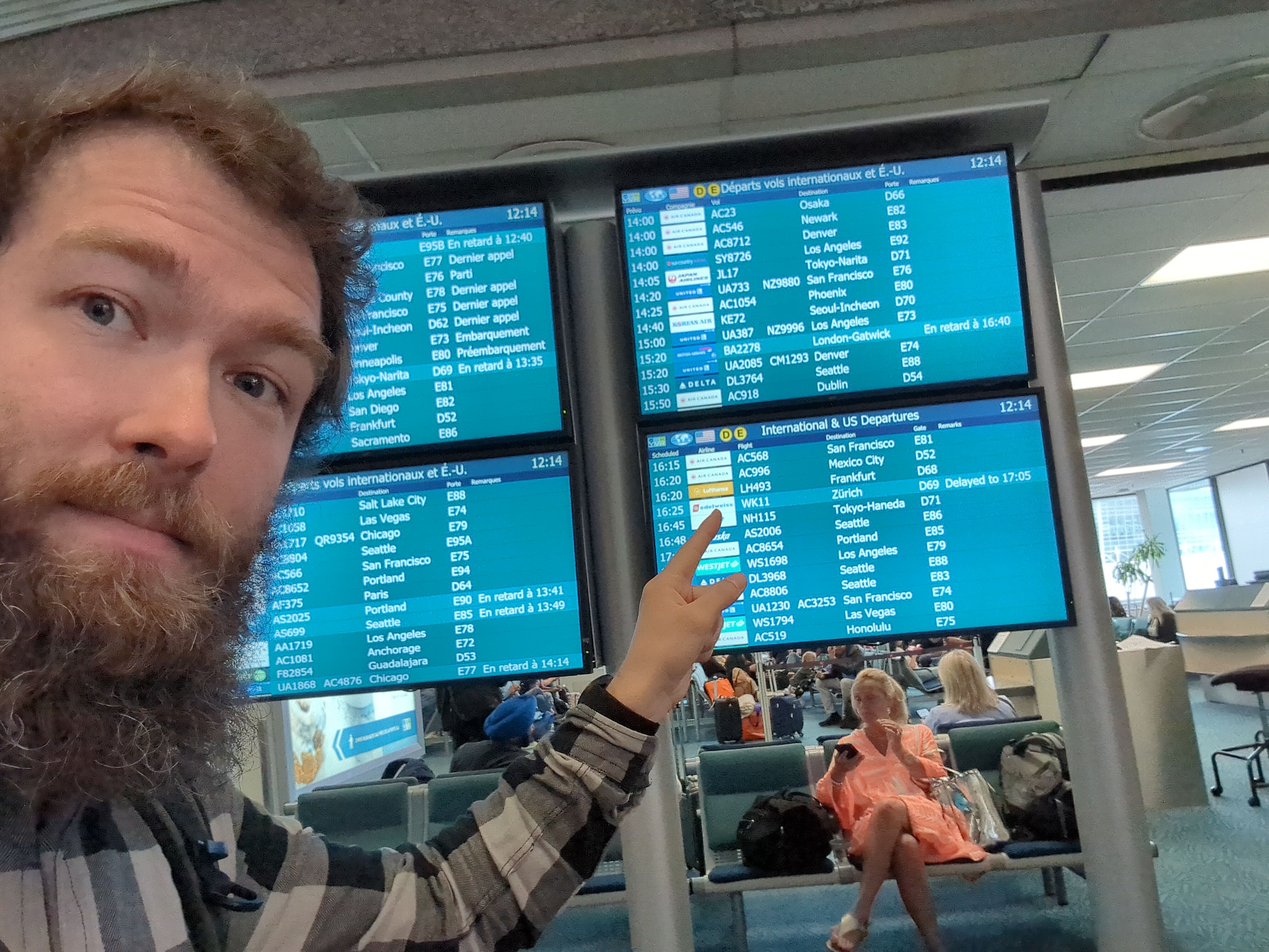 Myself, pointing to a display showing the Frankfurt Lufthansa flight at the Vancouver airport.