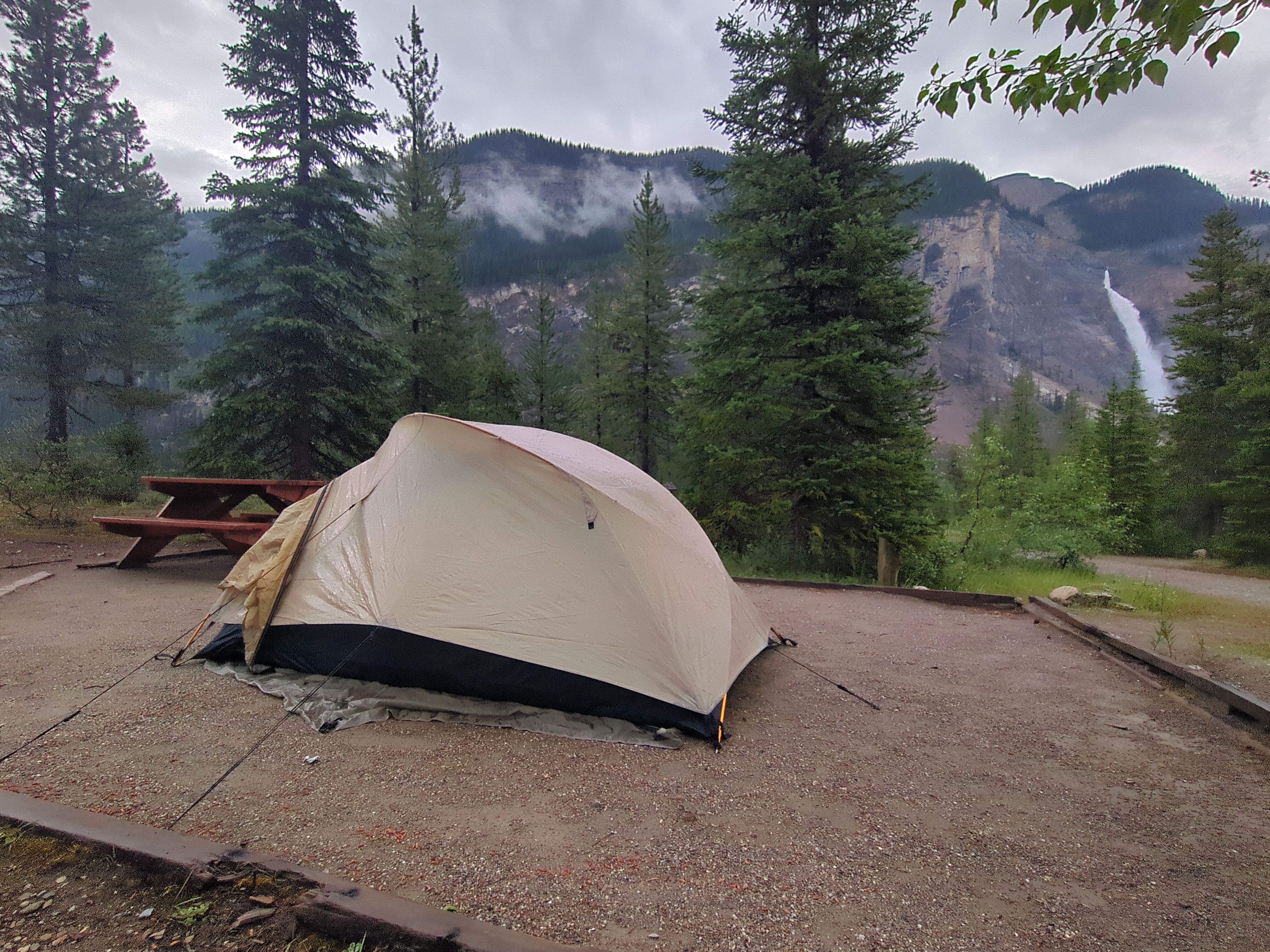 A tent on the Takakkaw falls campsite, with a view of the Takkakkaw waterfall itself.